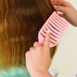 Speed Styler Detangling Brush in use, gently detangling a child's long hair. 